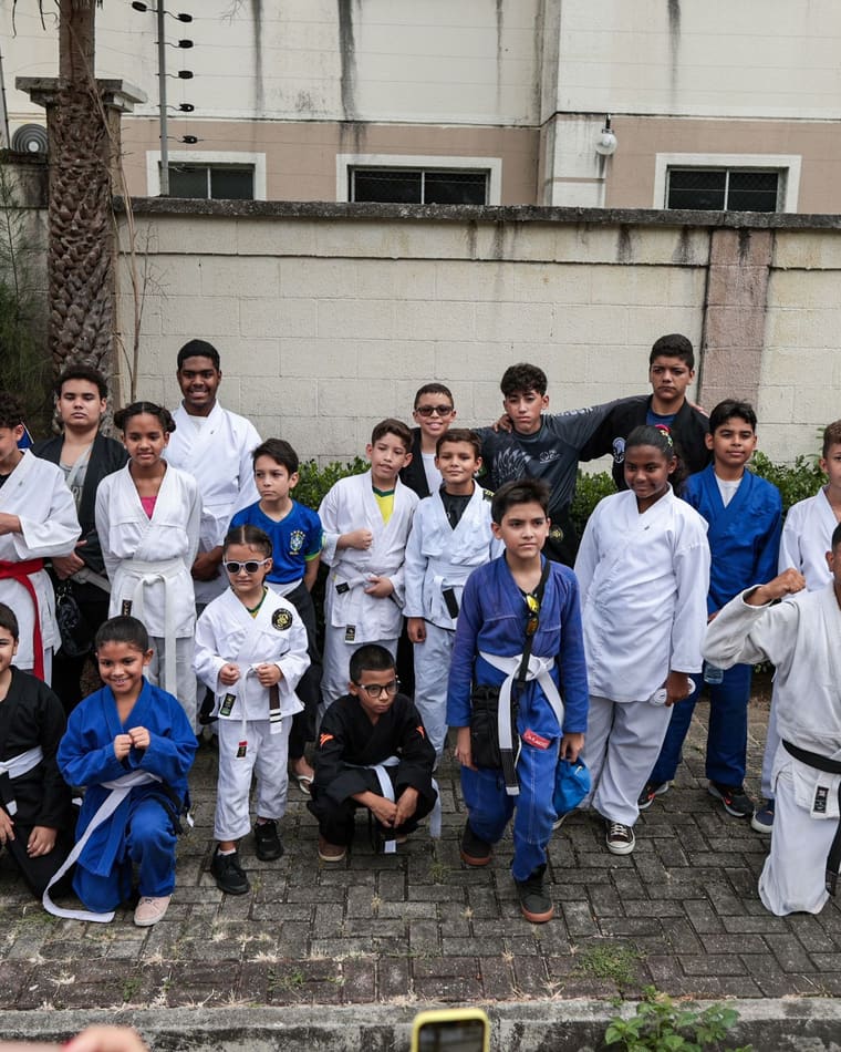 Turma de karatê e jiu-jitsu do colégio reunida, de kimono branco e azul